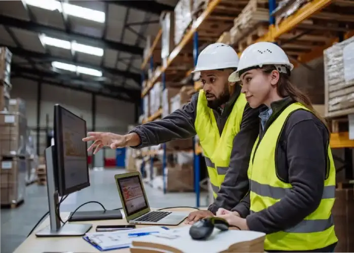 warehouse workers looking at inventory reports in the WMS