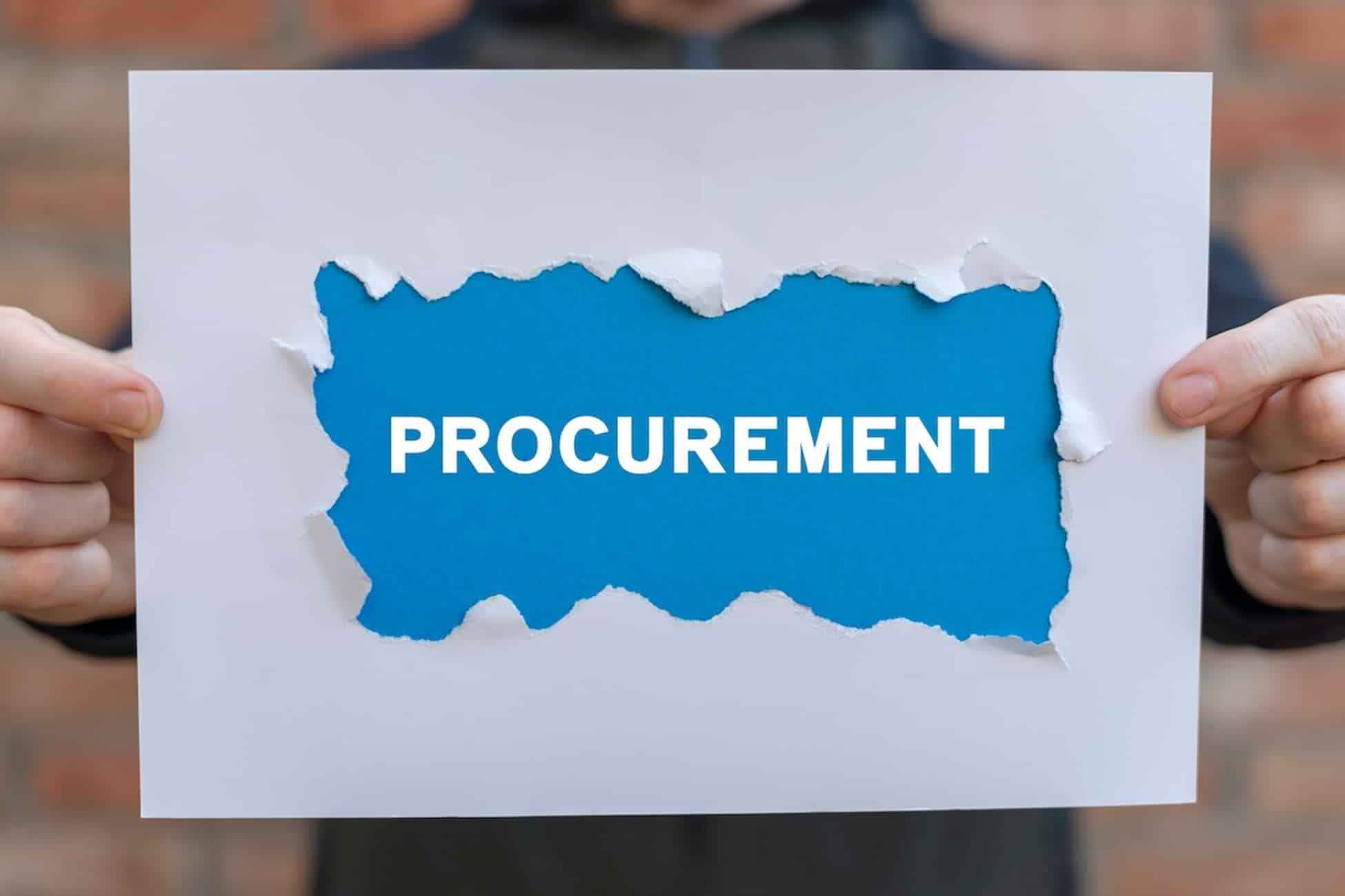 a person holding a piece of paper with the words procurement on it