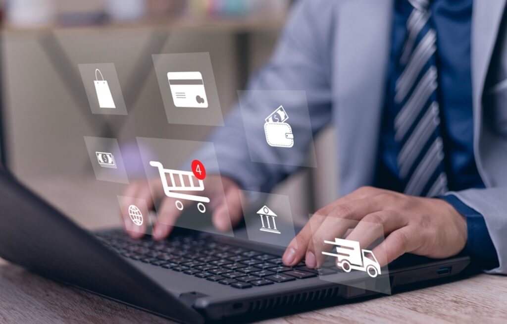 business man on a laptop with icons hovering above his hand showing the procurement process